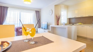 A modern hotel room with a dining area, a kitchen, and a living space. - Elegant apartment Mande 1 with a terrace in villa on Krk (Malinska)