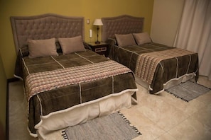 A double bed with a brown headboard and a patterned bedspread.