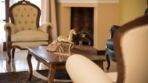 A living room with a fireplace, a sofa, and a coffee table with a horse figurine.