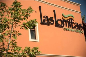 Een gebouw met een bord waarop staat 'Las Lomitas Casa de Campo'.