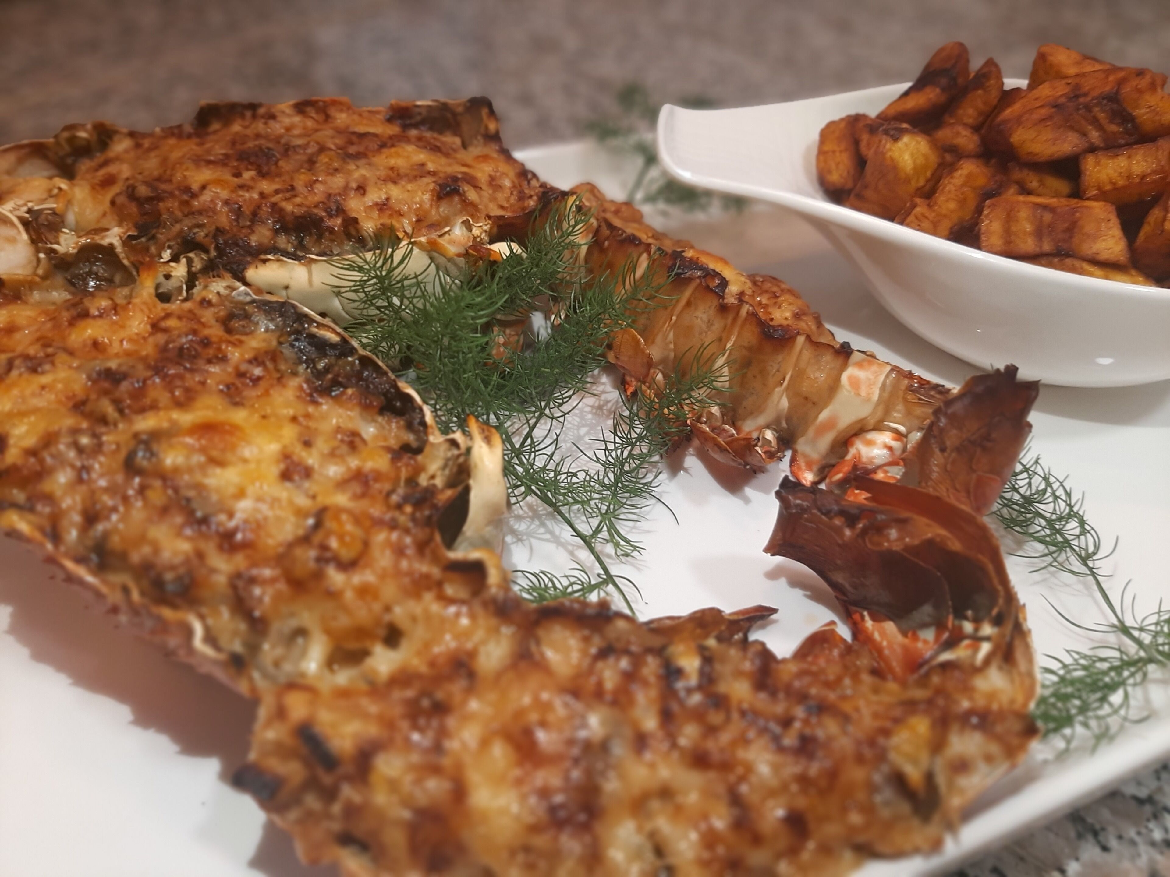 A plate of food with a baked dish, possibly a casserole, garnished with herbs.
