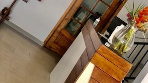 A reception desk with a wooden finish, a glass vase with flowers, and a modern light fixture. - Residence Hoteliere Flana B (Libreville)