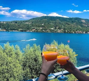 A scenic view of a lake with boats, surrounded by lush greenery and hills. - Hotel Chalet del Lago (Avigliana)