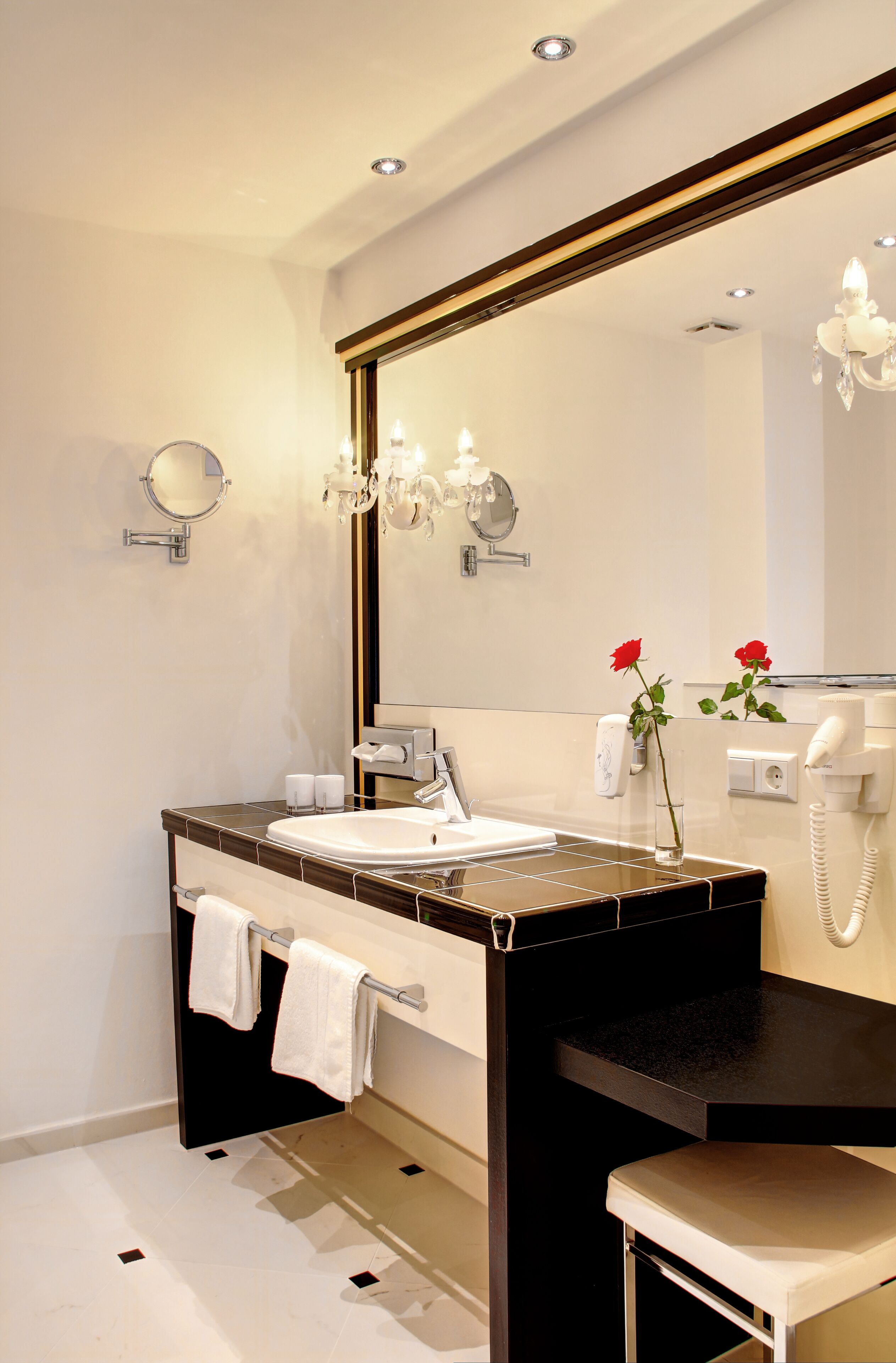 Een moderne badkamer met een grote spiegel, een wastafel, een wastafelmeubel en een toilet.