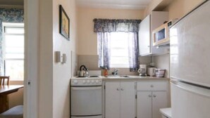 A compact kitchen with a stove, sink, and refrigerator. - Clairfont, Jobson's Cove / Warwick Long Bay/ Horseshoe Beach -  APARTMENT 2 (Warwick)
