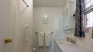 A bathroom with a toilet, a sink, a towel hanging on a rack, and a shower curtain. - Clairfont, Jobson's Cove / Warwick Long Bay/ Horseshoe Beach -  APARTMENT 3 (Warwick)