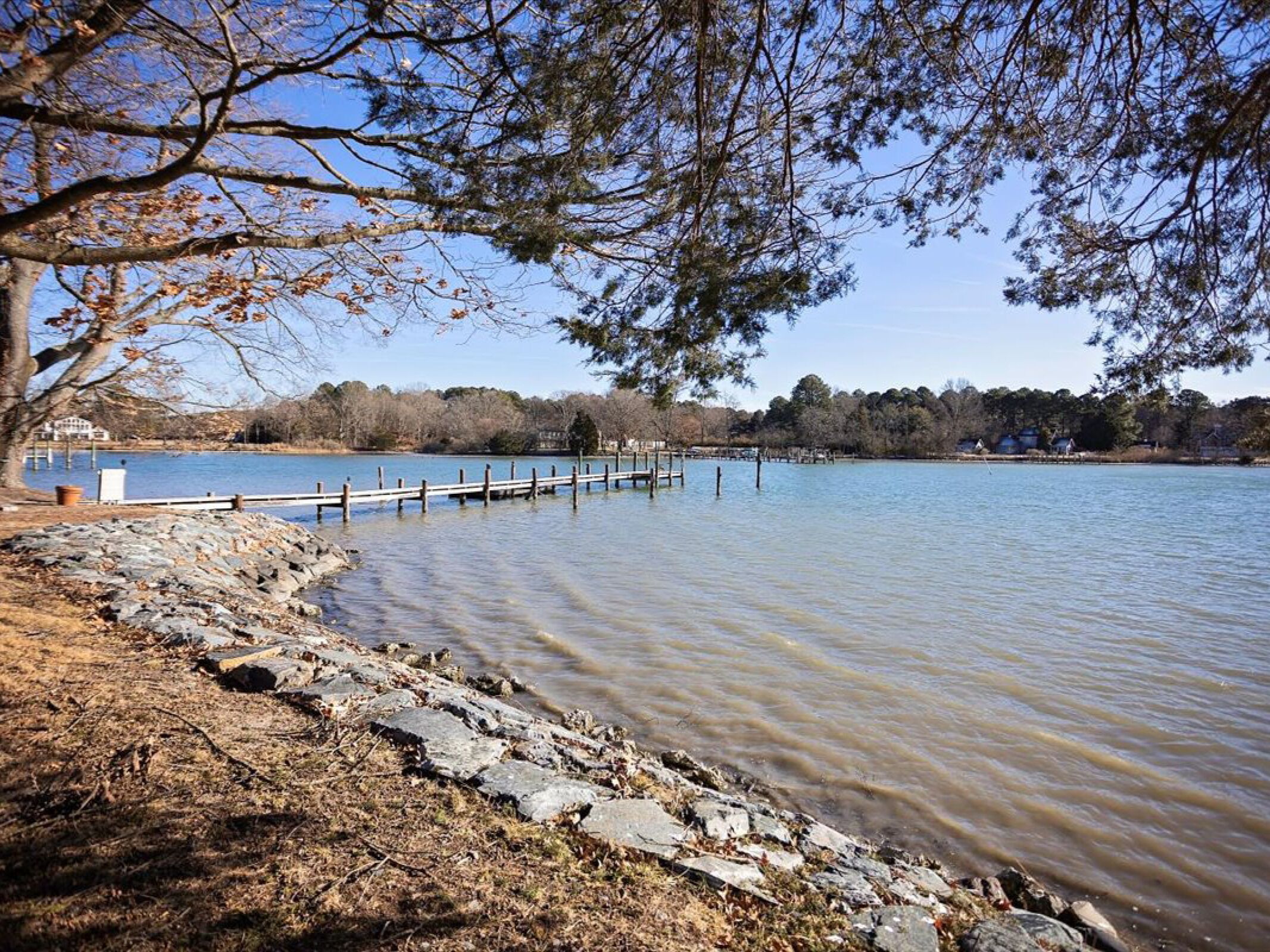 Peaceful lake setting with private dock and wooded shoreline creates a tranquil waterfront retreat.
