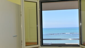Une chambre avec une fenêtre donnant sur la plage.