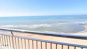 Une vue sur la plage depuis un balcon doté d’une balustrade.