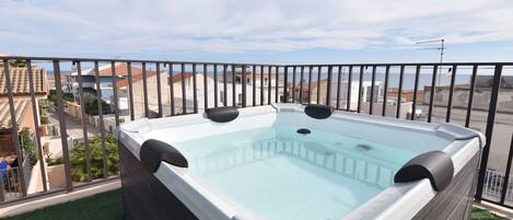 Un jacuzzi en la azotea con vistas despejadas del paisaje urbano.
