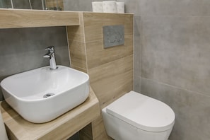 A bathroom with a white sink, a toilet, and a mirror above the sink. - Warsaw Concierge Royal Castle View (Warsaw)