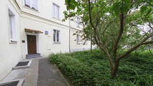 Un bâtiment doté d’une entrée pavée, d’une porte et d’une petite fenêtre.