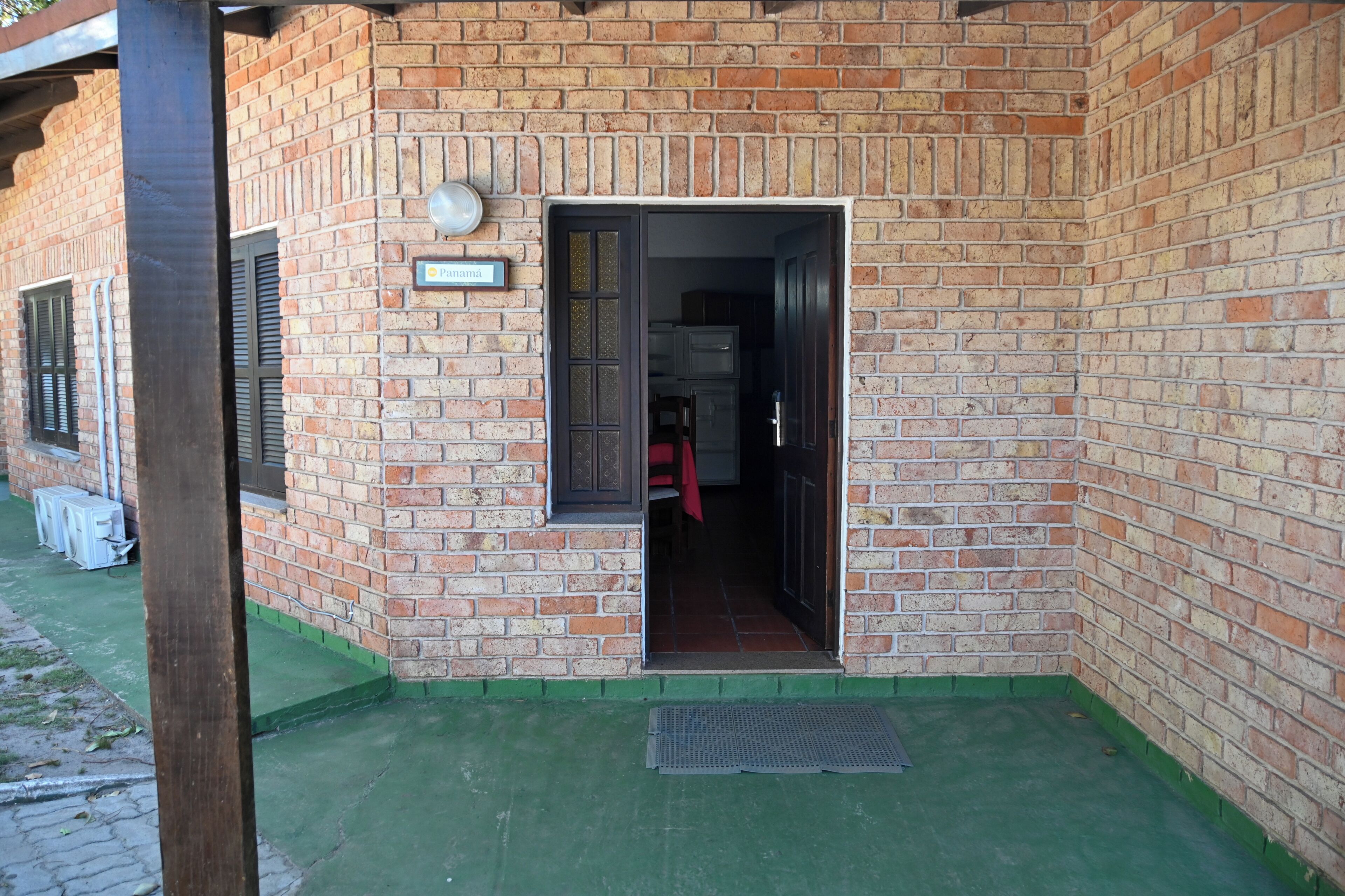 A brick building with a door leading to an interior space.
