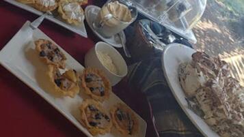 A buffet table with various desserts and pastries.