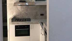 Una cocina moderna con estufa a gas, horno y microondas empotrados.