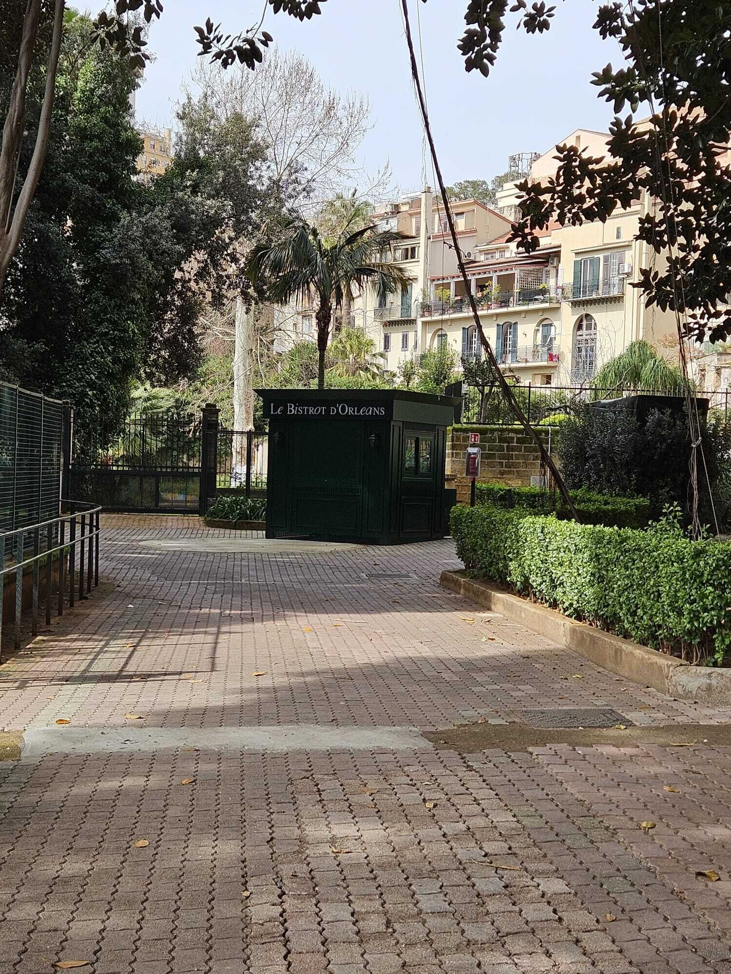 Un chemin pavé mène à un bâtiment vert portant l’inscription « Le Bistrot d’Orléans ».