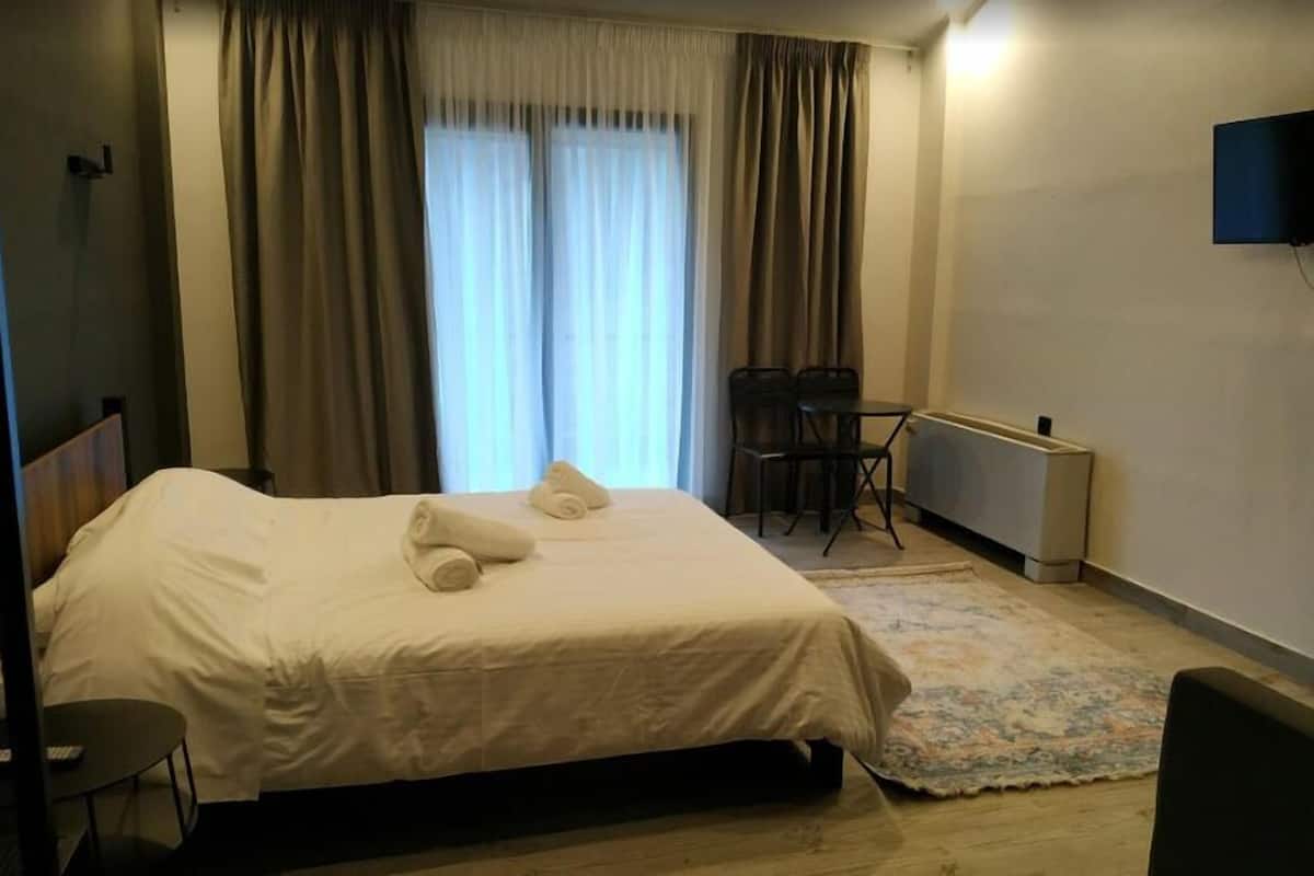 Escritorio, cortinas blackout y tabla de planchar con plancha