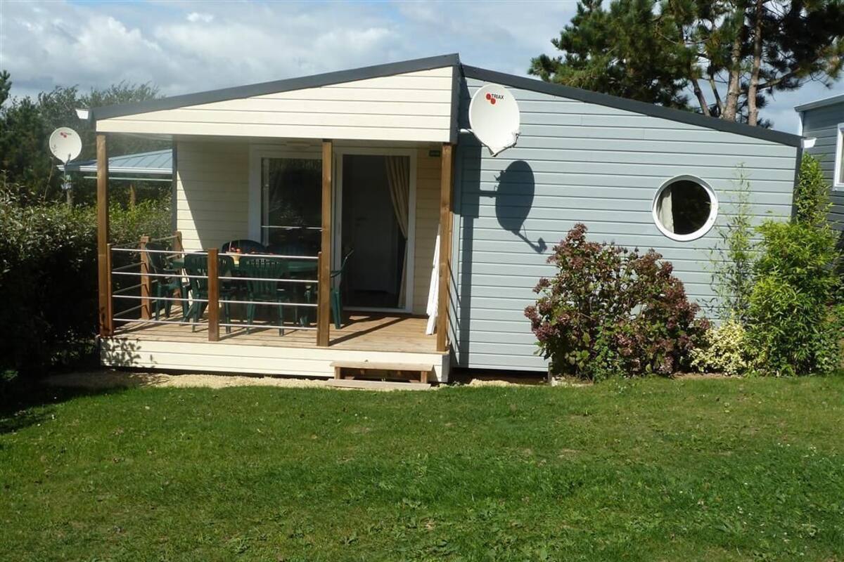 A small, single-story building with a covered patio area and a satellite dish.