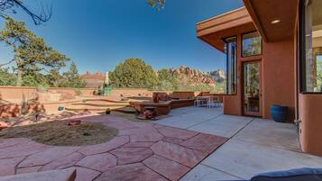 A patio with stone flooring, outdoor furniture, and a view of red rock formations.