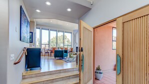 A spacious living area with a dining table and chairs, a sofa, and a staircase leading to an upper floor. - Experience luxury in Sedona Painted Sky—sleeps 8 with stunning panoramic views. (Sedona)