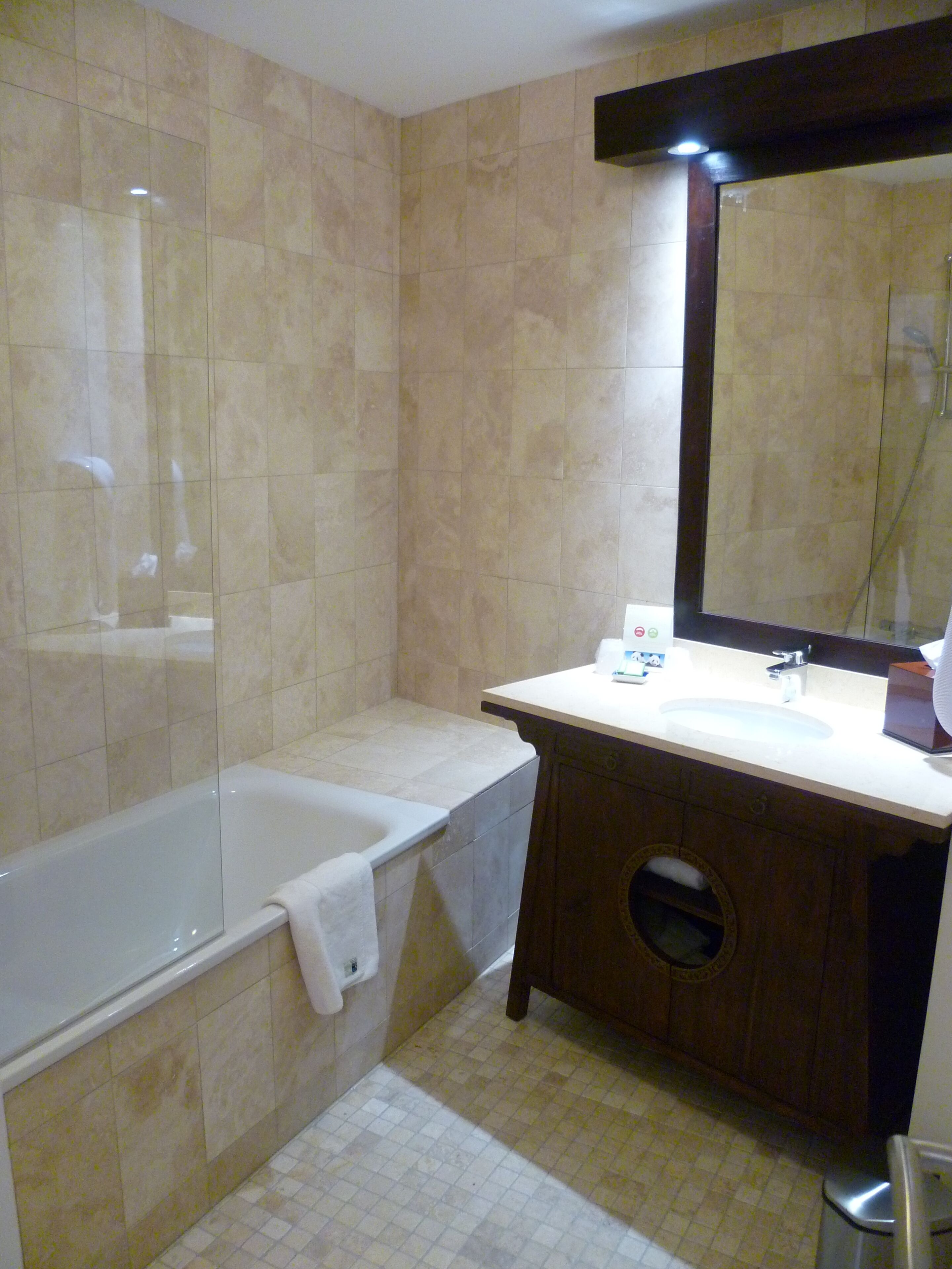 Un baño con bañera, lavamanos y espejo.