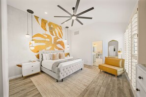 A bedroom with a bed, bedside tables, a ceiling fan, and a large mirror. - Casa Havana  Stunning Views Pool Spa PGA West 4br (La Quinta)
