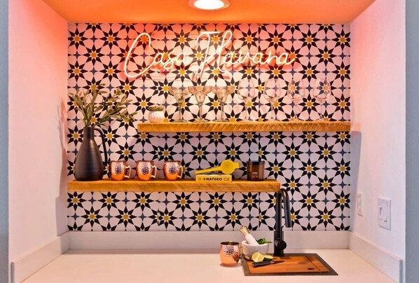 A kitchen with a geometric patterned backsplash, a neon sign, and shelves with kitchenware. - Casa Havana  Stunning Views Pool Spa PGA West 4br (La Quinta)