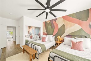 A hotel room with two beds, a ceiling fan, a wooden bench, and a large abstract mural on the wall. - Casa Havana  Stunning Views Pool Spa PGA West 4br (La Quinta)