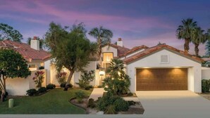 A residential house with a garage, surrounded by well-maintained landscaping and palm trees. - Casa Havana  Stunning Views Pool Spa PGA West 4br (La Quinta)