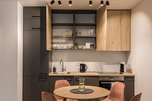 Réfrigérateur, un four, cafetière-théière, vaisselle et ustensiles