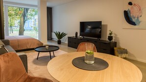 Una sala de estar moderna con un sofá, una mesa de centro, un televisor y una mesa de comedor.