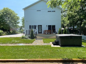 A white single-story house with a front porch, a small garden, and a hot tub. - The White House - spacious 5 bedroom, with hot tub - blocks from everything!!!! (New Buffalo)
