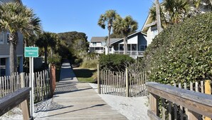 A wooden boardwalk leading to a beach area with a sign indicating 'Beachwood East 1'.