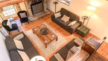 A cozy living room with a fireplace, sofas, and a coffee table.