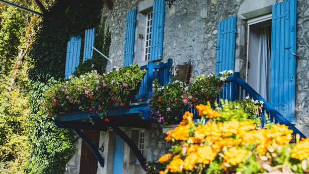 A stone building with blue shutters and a balcony with flowers. - Le Moulin de Dingy - House with 6 bedrooms & swimmingpool 20 mn from Annecy (Dingy-Saint-Clair)