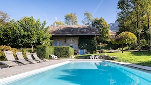 A swimming pool with lounge chairs and a stone building in the background. - Le Moulin de Dingy - House with 6 bedrooms & swimmingpool 20 mn from Annecy (Dingy-Saint-Clair)