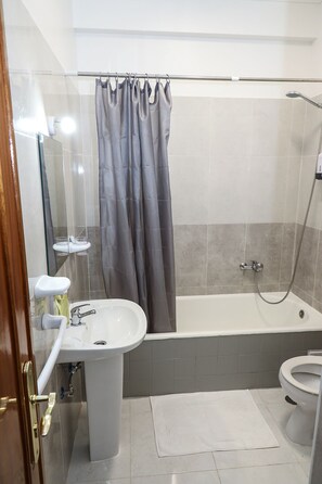 A bathroom with a bathtub, a toilet, and a sink. - Lisbon Home Host - Hostel (Lisbon)