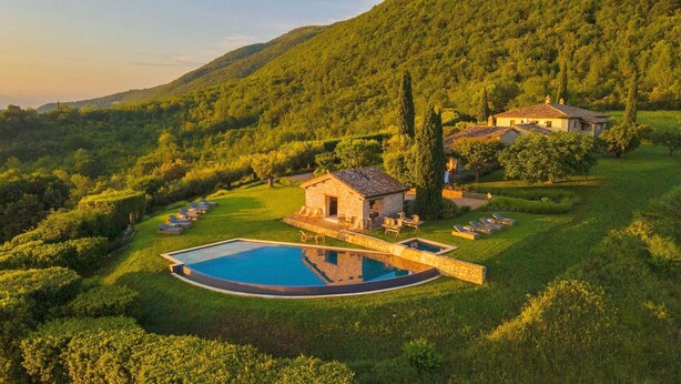 A villa with a swimming pool surrounded by lounge chairs, set in a lush, hilly landscape. - VILLA AMANTA - Nine Bedroom Villa, Sleeps 16 (Perugia)