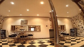 Enjoy meals in this inviting dining area with a checkered floor and a mirrored wall above a table.