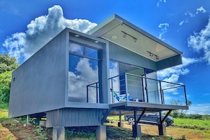 A modern, two-story house with large windows and a balcony. - Inspire Costa Rica (Alajuela)