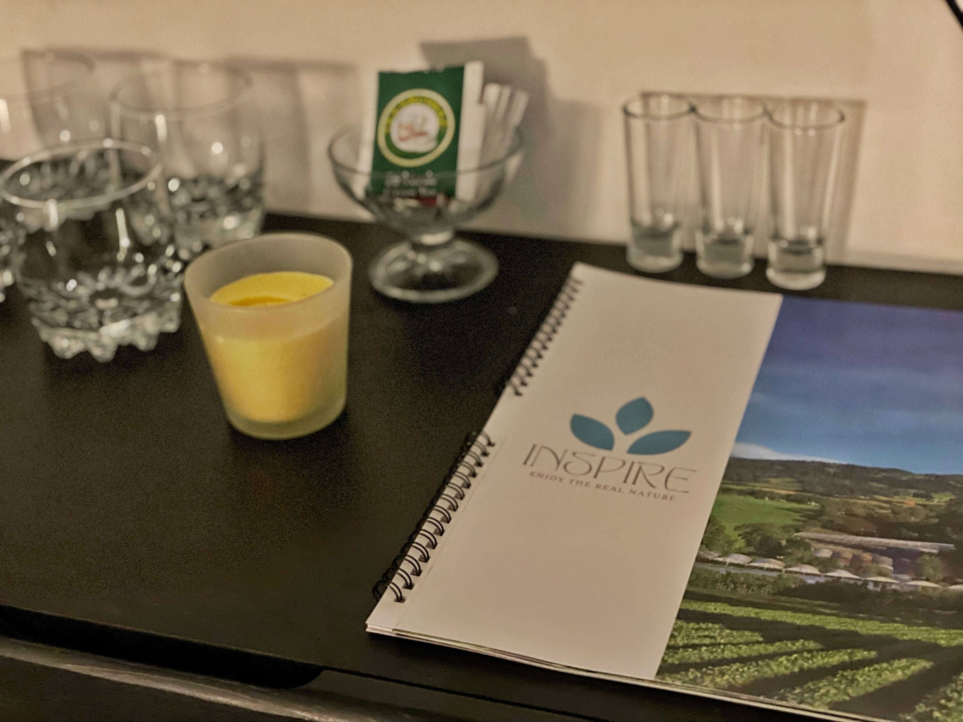 A table with a notebook, a candle, and glasses.