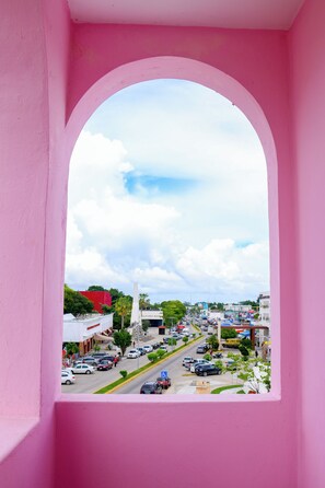 A pink archway overlooking a busy street with cars and buildings. - Rosa del Alba, Barrio Mágico Centro Histórico de Chetumal (Chetumal)