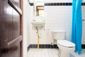 A bathroom with a white sink, toilet, and blue shower curtain. - Rosa del Alba, Barrio Mágico Centro Histórico de Chetumal (Chetumal)
