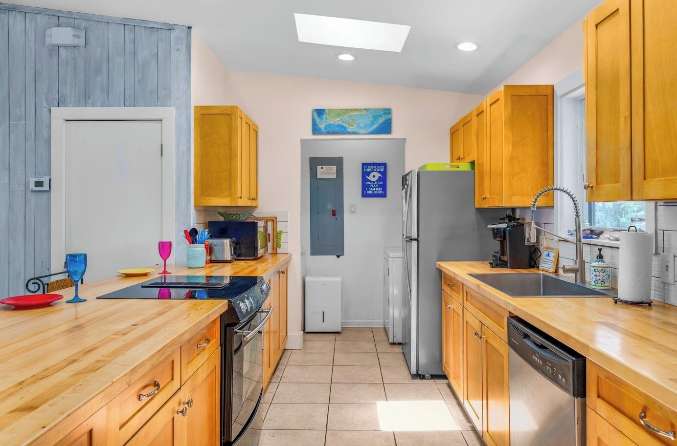 A compact kitchen with wooden cabinets, a microwave, a refrigerator, and a sink.