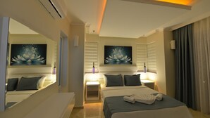 A hotel room with a large bed, two bedside tables with lamps, a large mirror, and artwork on the walls. - 4 bedroom luxury villa sardunya B in oludeniz fethiye (Fethiye)