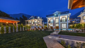 A modern two-story house with a swimming pool, surrounded by well-maintained lawns and a mountain backdrop. - 4 bedroom luxury villa sardunya B in oludeniz fethiye (Fethiye)