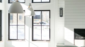 A modern interior with large windows, pendant lighting, and a fireplace. - Modern Nordic Villa 3 miles from Beaver Stadium (State College)