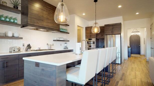 Une cuisine moderne dotée d’un îlot central, d’un coin bar et d’un mur d’accent en bois.