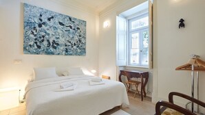 Ein Hotelzimmer mit einem großen Bett, einem Schreibtisch, einem Stuhl und einem Fenster.