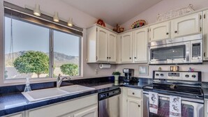 A kitchen with white cabinets, a stainless steel dishwasher, a double oven, and a microwave. - Unobstructed mountain views (Tucson)